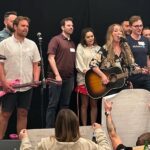 a group performing a song at a team building event